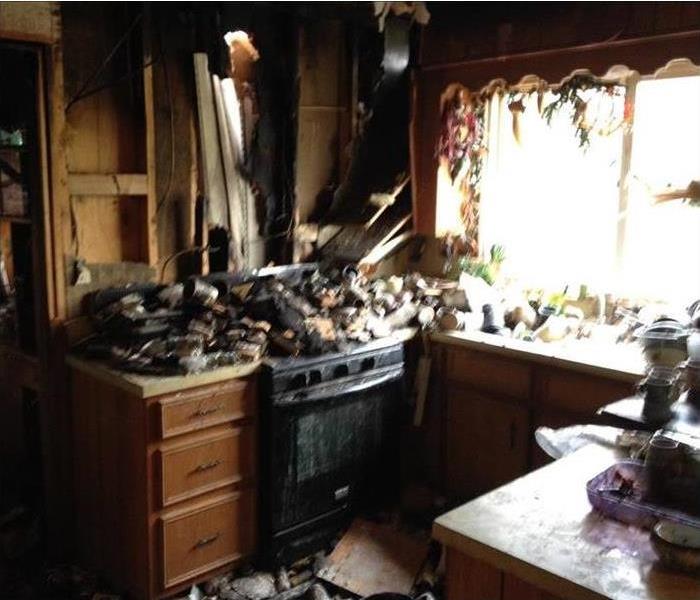 charred and burnt, devastated kitchen , blackened stove